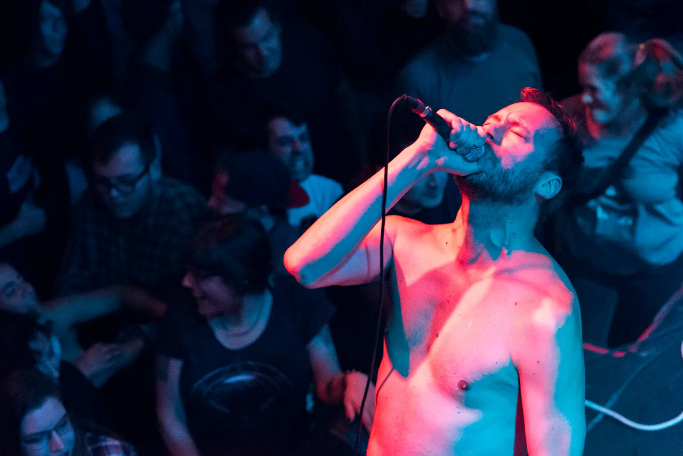 A vocalist leaning into the crowd during a live performance.