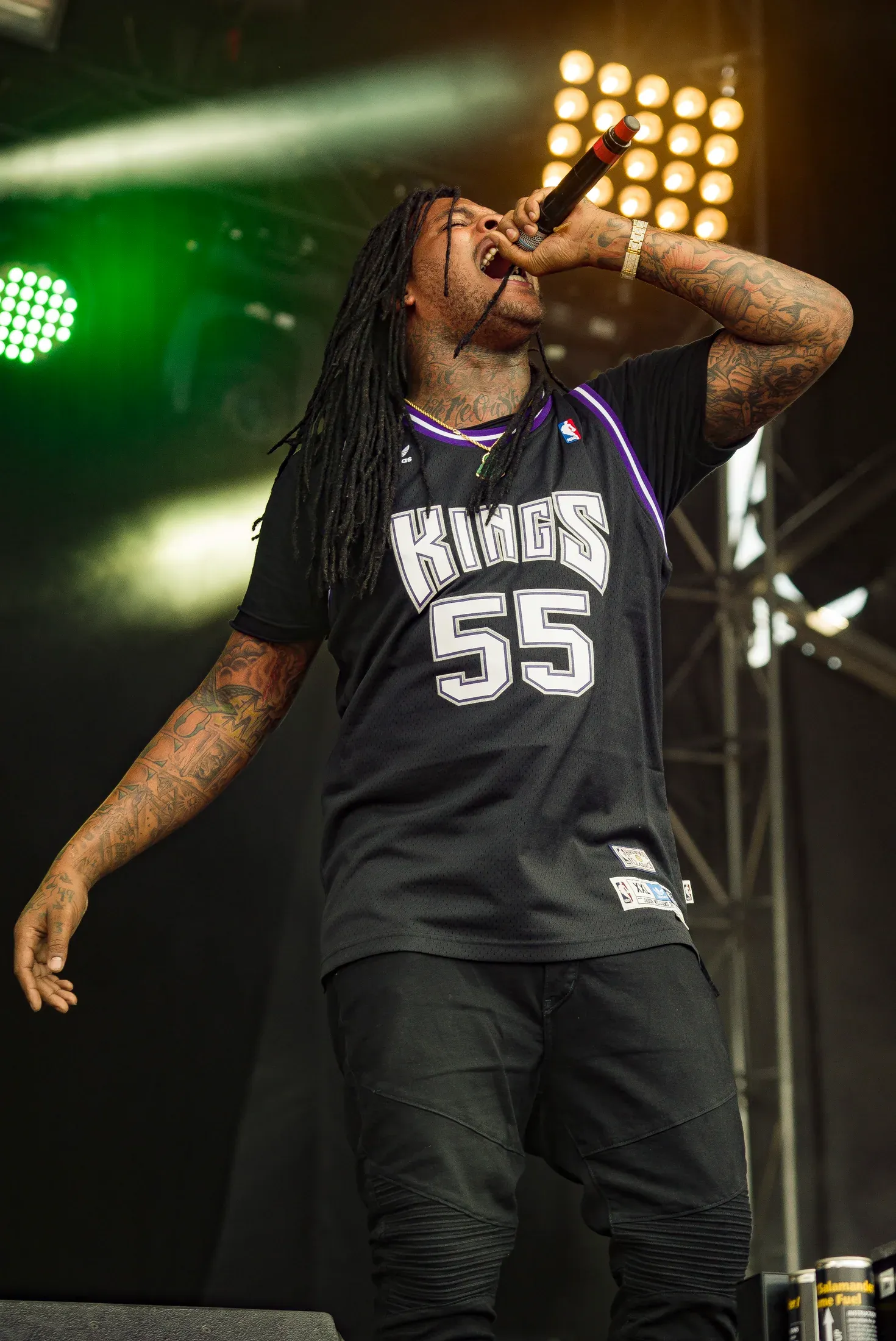 A vocalist performing under green stage light.