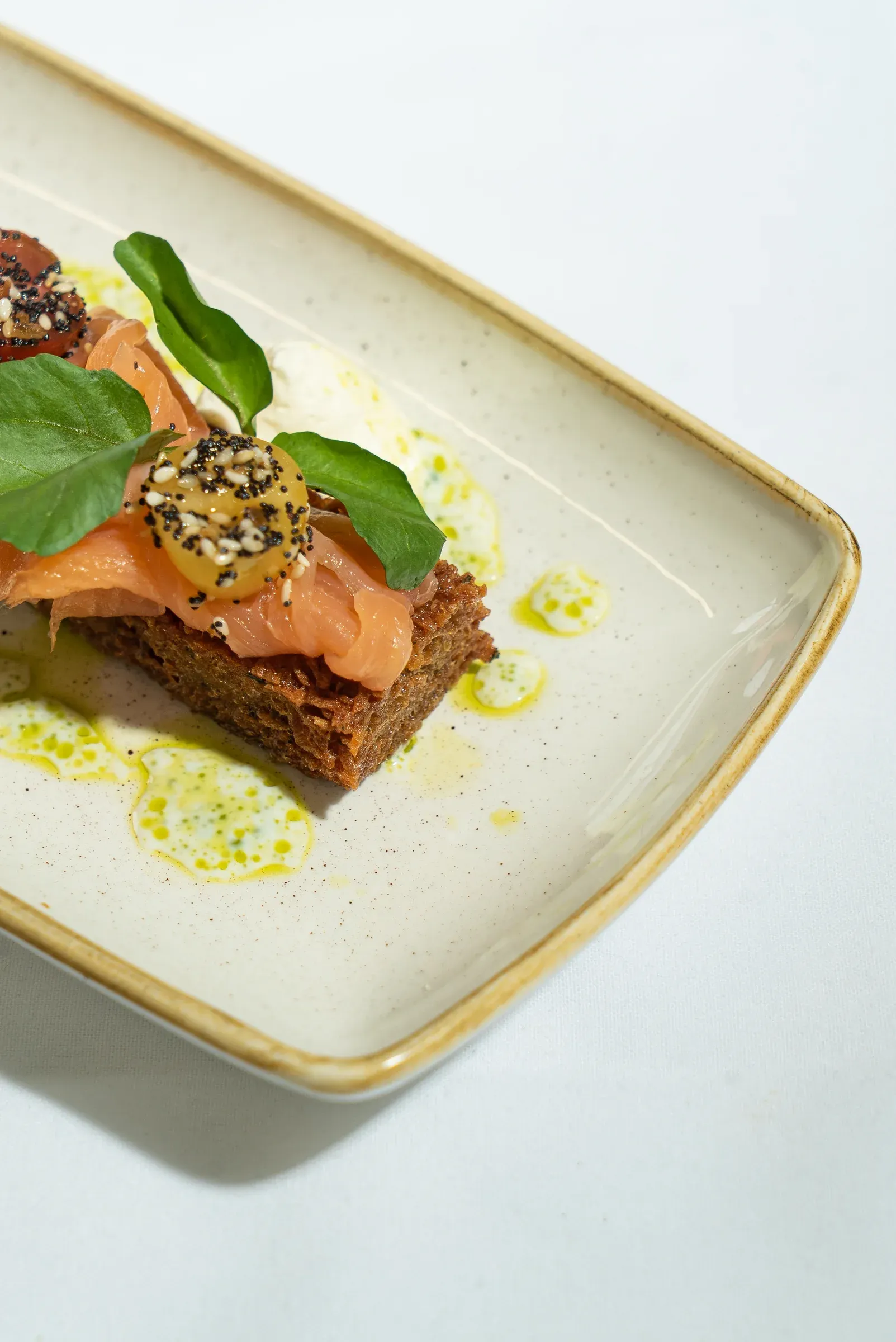 A composed toast dish presented on a white rectangular plate.