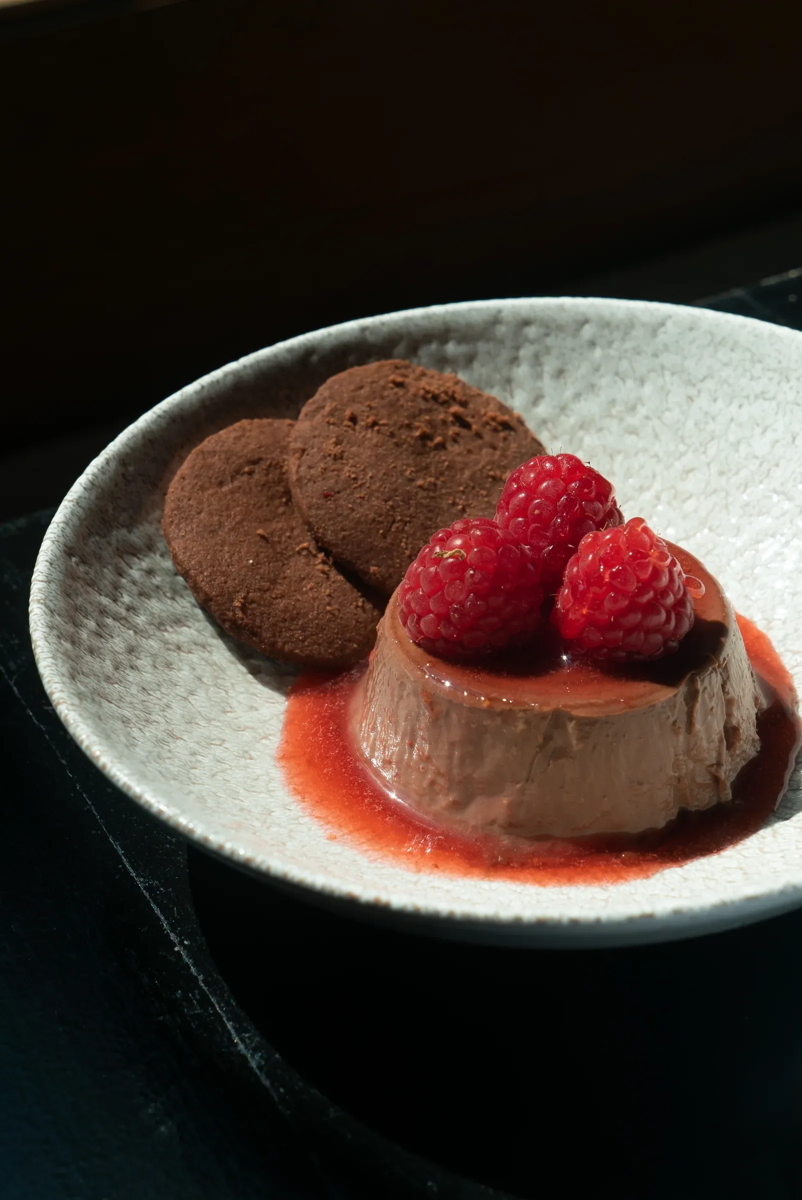 Chocolate dessert served with raspberries.