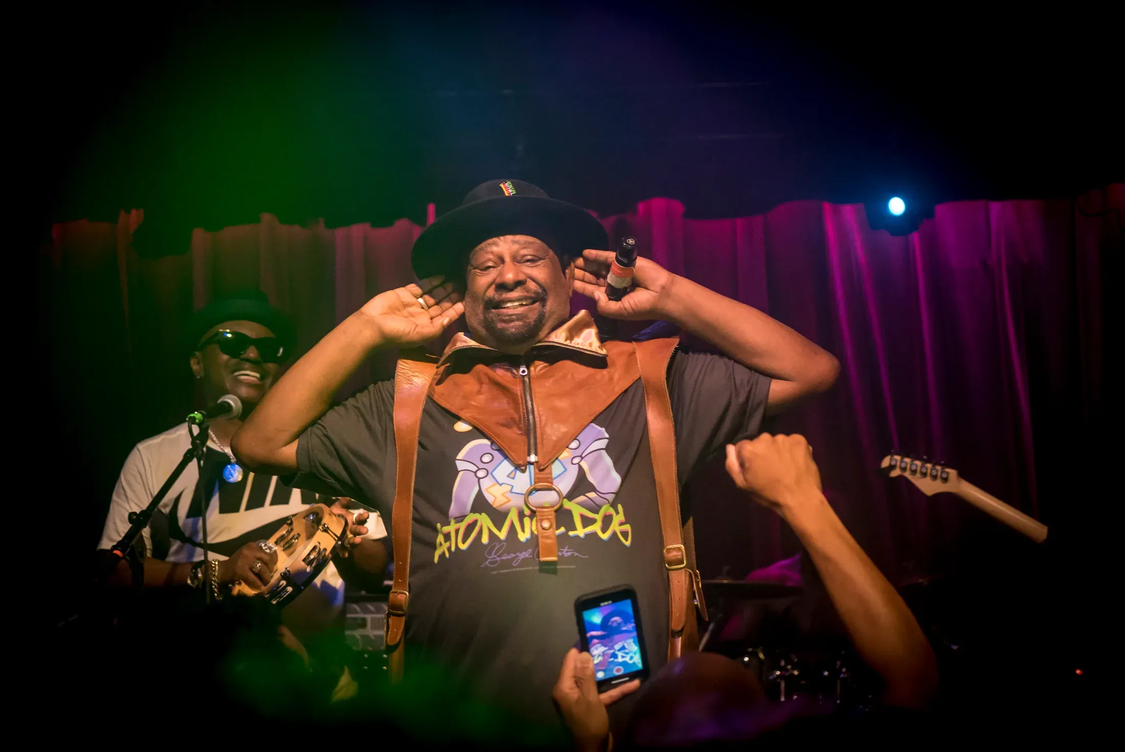 A performer smiling on an intimate stage.