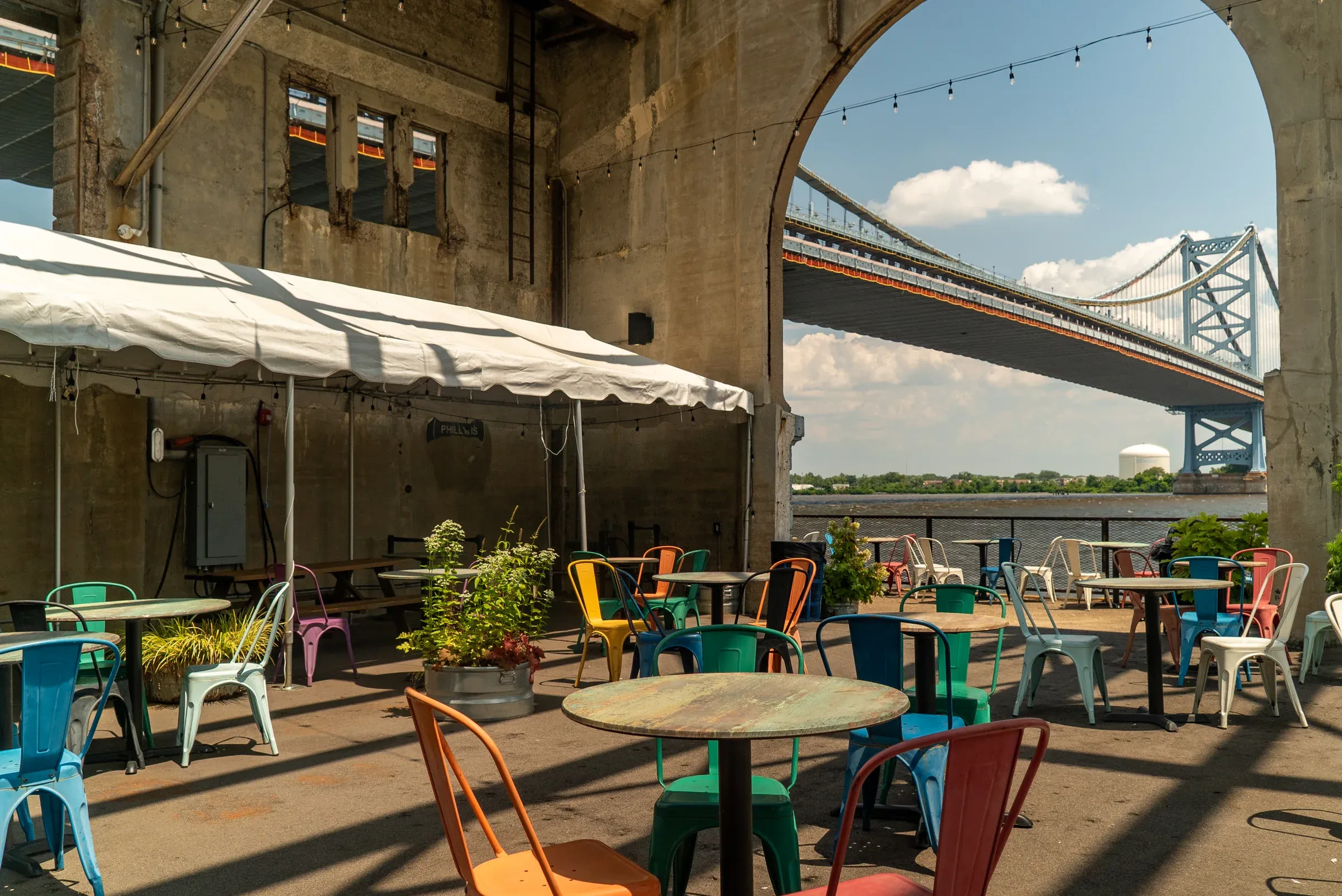 A colorful hospitality patio beneath the Ben Franklin Bridge.