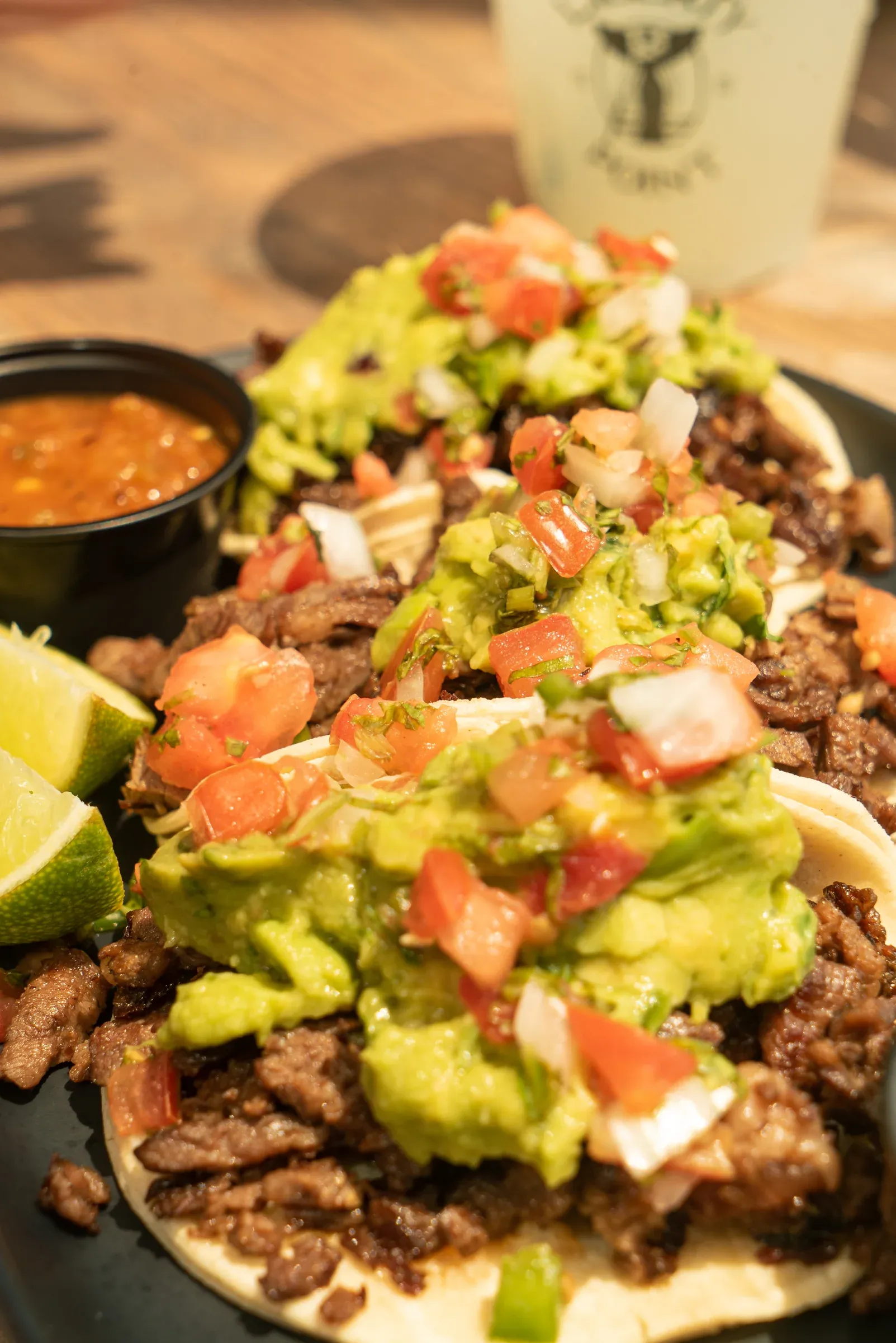 A taco plate topped with avocado and pico de gallo.