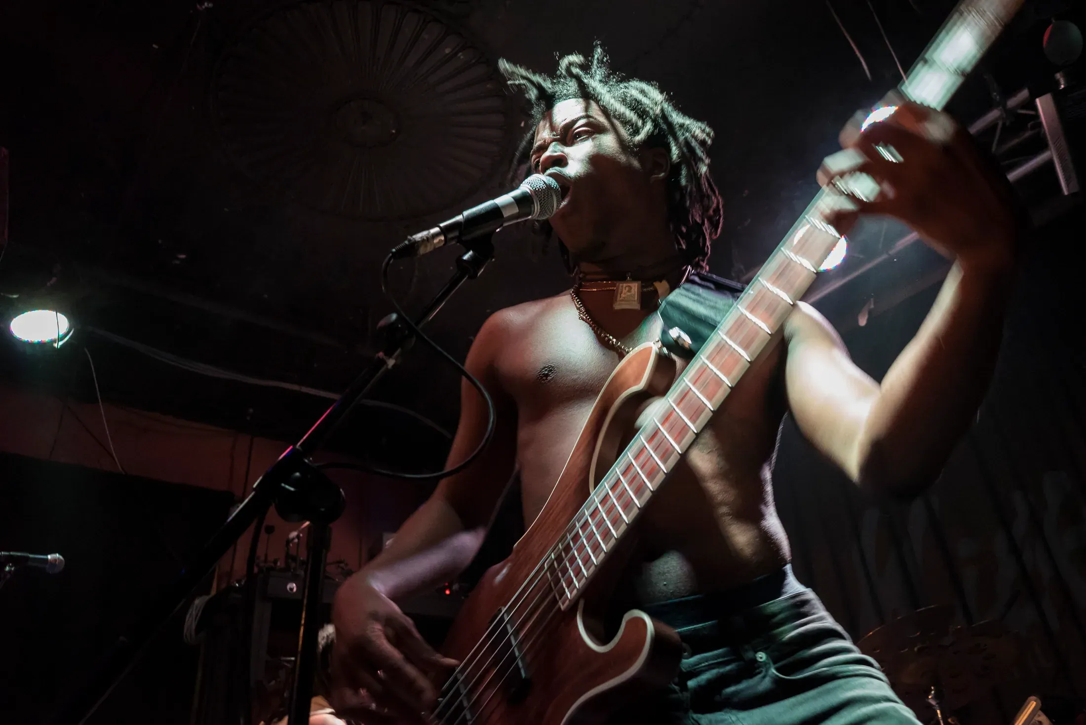 A guitarist performing under stage lights.