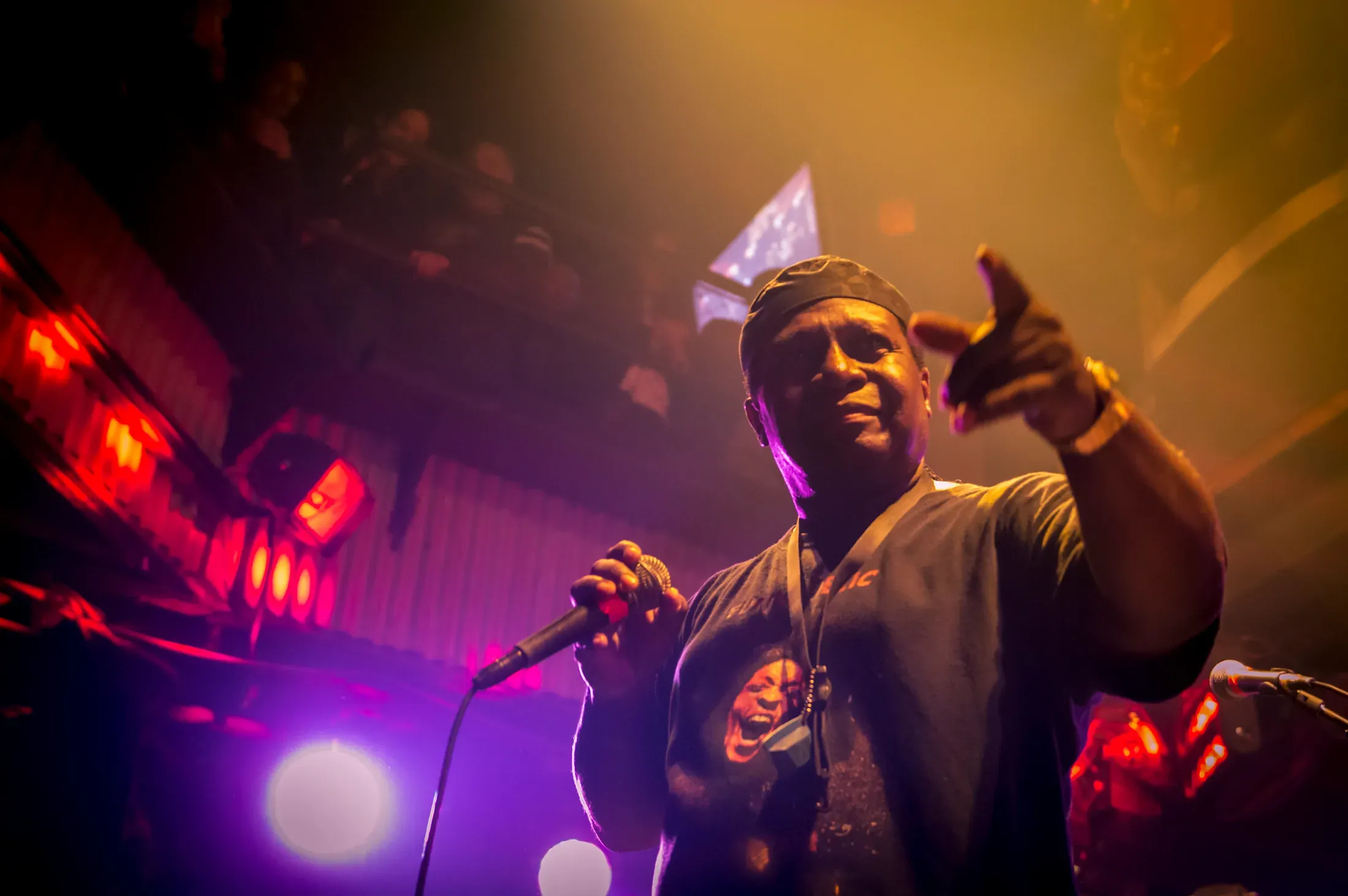 A performer photographed from below under red stage light.