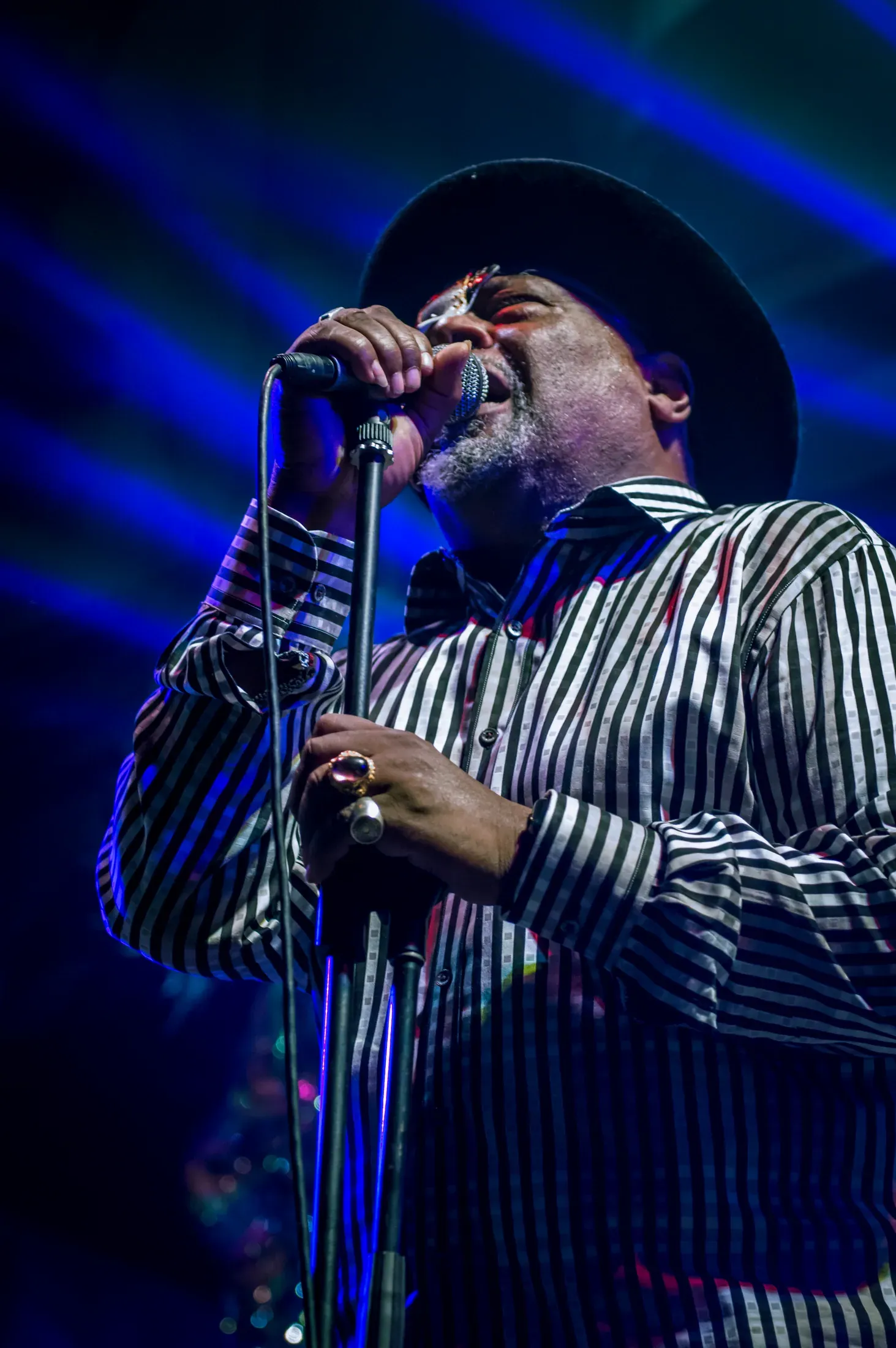 A musician playing saxophone under blue light.