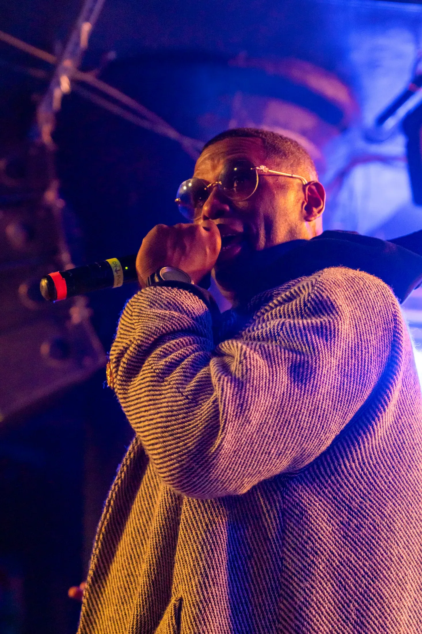 A vocalist performing in purple stage light.