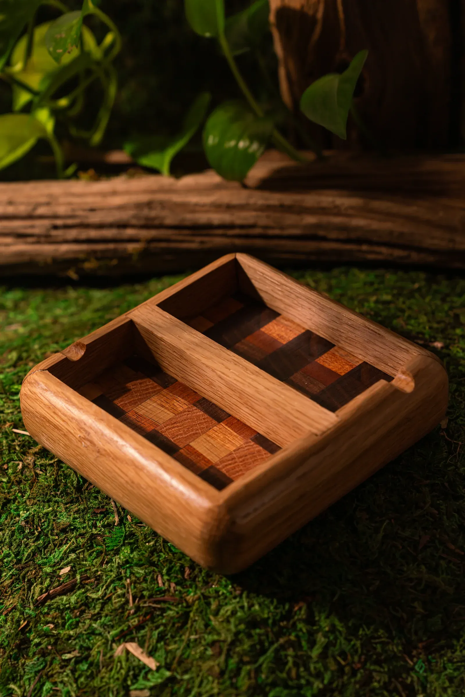 Handcrafted wooden tray photographed on a moss-covered set.