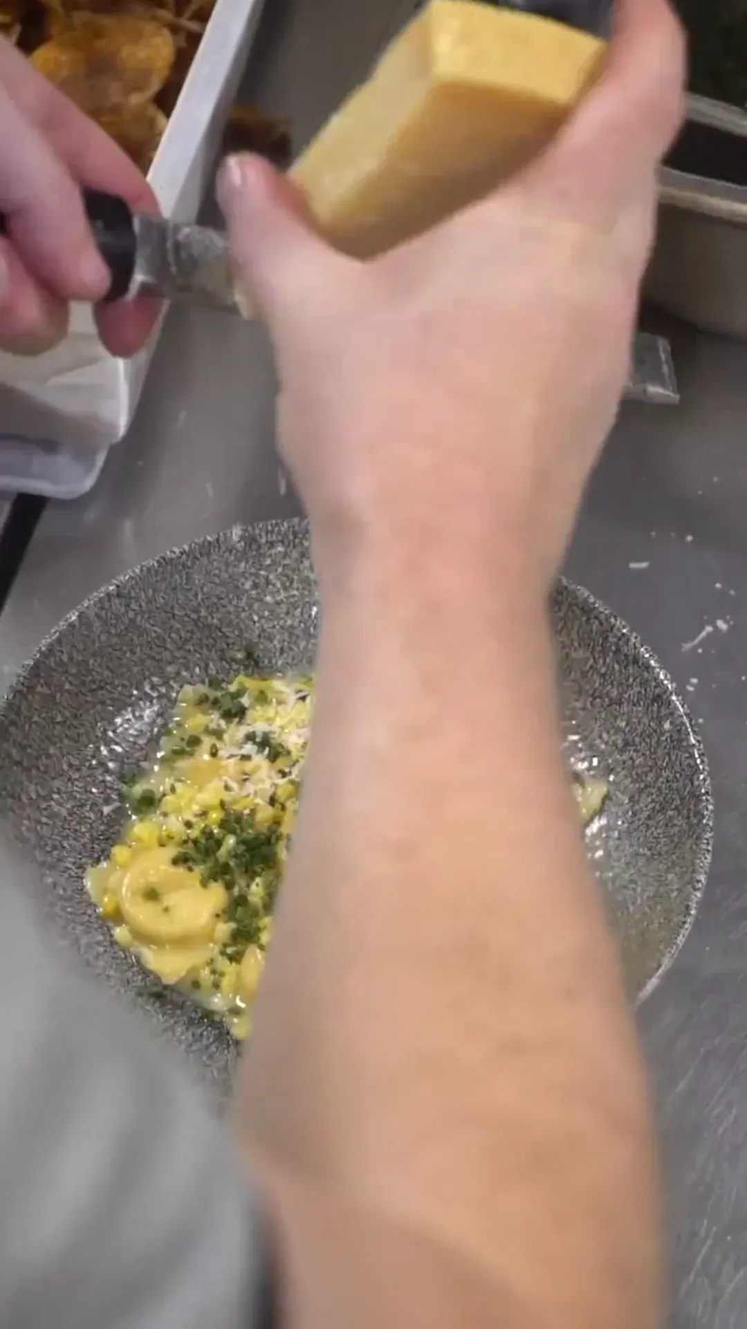 A skillet dish receiving its final tableside garnish.